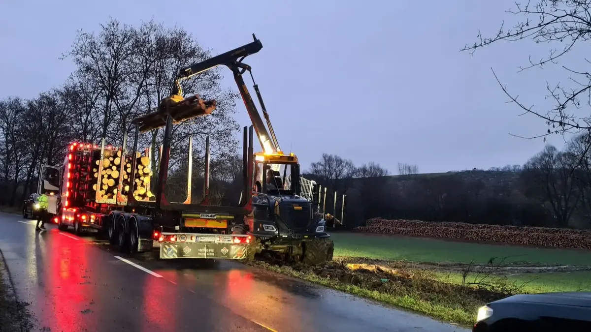 Timber truck and loader working at dusk